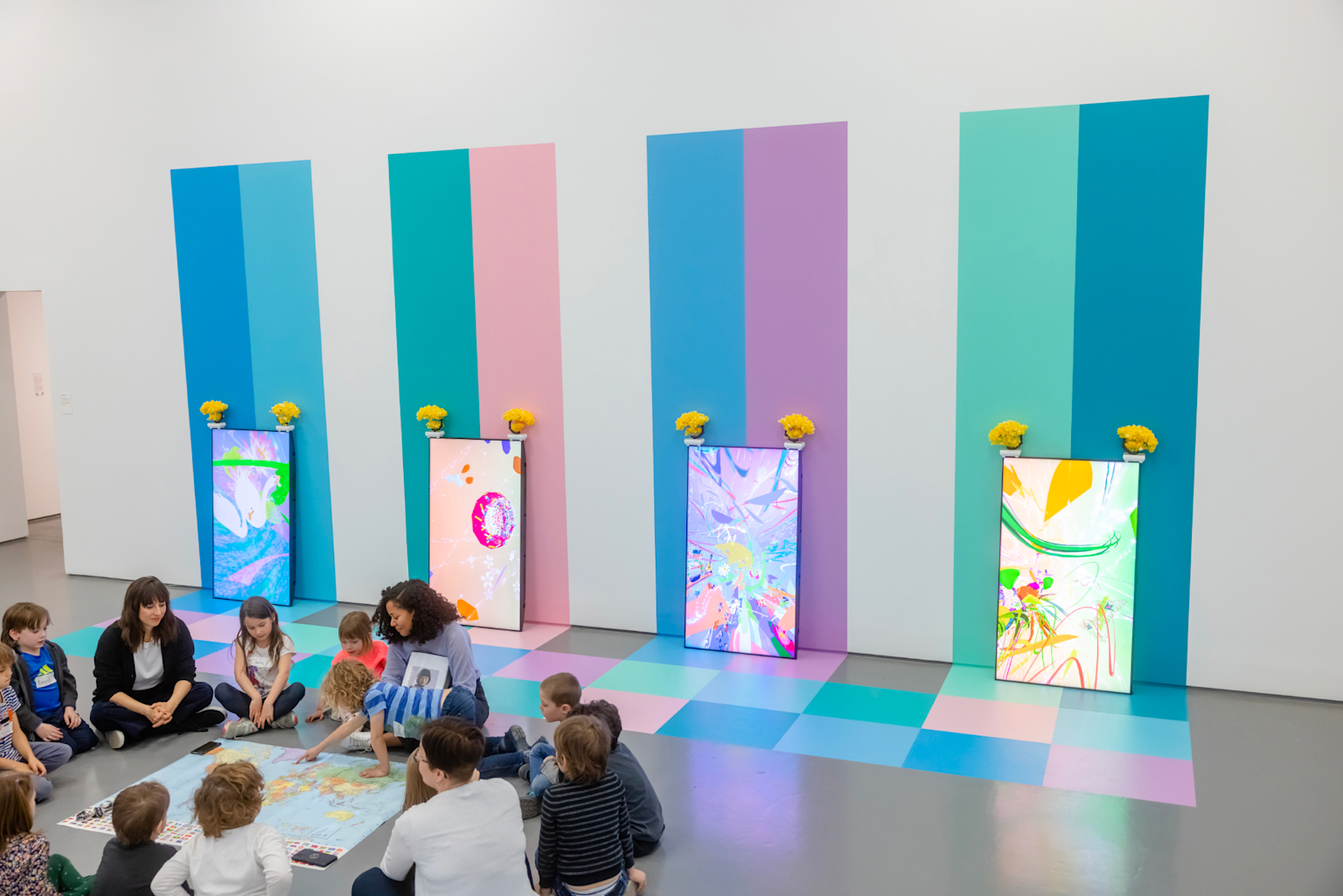Children at interactive educational display in modern museum with colorful digital screens and mapping activity