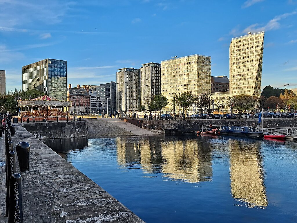 Liverpool modern waterfront development with contemporary buildings, carousel, and calm water reflections